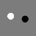 A white spot and a black spot on a uniform middle-gray background.